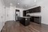 Modern kitchen with sleek dark cabinetry, granite countertops, stainless steel appliances, and elegant wood flooring.