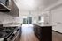 Bright, modern kitchen with elegant granite countertops, stainless steel appliances, and expansive windows letting in natural light.