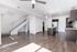 Modern open-plan living area with sleek hardwood floors, stylish kitchen with granite countertops, and a contemporary staircase.