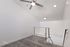 Modern loft space with plush carpet, sleek railing, and stylish ceiling fan, ideal for a home office or relaxing retreat.