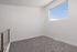 Bright, modern room featuring plush carpeting, a sleek railing, and a large window providing natural light.
