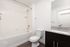 Elegant modern bathroom with sleek fixtures, featuring a granite countertop and polished dark cabinetry.