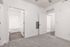 Modern apartment interior featuring a carpeted room with a bathroom entrance and sleek wooden flooring.
