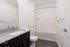 Elegant bathroom featuring modern fixtures, a sleek granite countertop, and inviting bathtub, perfect for relaxation.