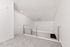 Sleek modern loft space with plush carpeting and stylish metal railing, perfect for a creative living area.