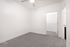 Bright, modern bedroom with plush carpeting and a ceiling fan, featuring a spacious walk-in closet.