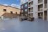 Modern apartment exterior with a spacious patio, sleek outdoor seating, and contemporary architecture, ideal for urban living.