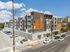 Modern apartment building with stylish facade, ample balconies, and convenient parking in a vibrant urban setting.