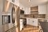 Modern kitchen with sleek stainless steel appliances, elegant white cabinetry, and stylish tiled backsplash.