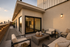 Luxurious rooftop patio with elegant seating, ambient lighting, and stunning sunset city views.