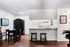 Charming open-concept dining and kitchen area with warm wooden floors, a cozy dining set, sleek breakfast bar, and stylish decor.