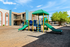 Inviting apartment complex featuring a vibrant playground with green slides, perfect for families seeking a friendly community atmosphere.