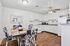 Charming open-concept kitchen and dining area featuring sleek white cabinetry, elegant decor, and a cozy dining table set on rich wooden flooring.