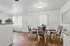 Inviting dining area with elegant patterned chairs, natural light, and warm wood flooring in a modern apartment.