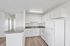Bright, modern kitchen with a sleek white design, featuring ample cabinetry, a spacious countertop, and elegant flooring.
