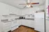Bright, well-appointed kitchen with modern appliances, gleaming white cabinets, and stylish wood flooring, perfect for culinary adventures.