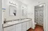 Elegant bathroom with dual sinks and a floral-patterned shower curtain, featuring modern lighting and ample counter space.