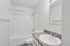 Bright and modern bathroom featuring a sleek white bathtub, elegant vanity, and contemporary fixtures.