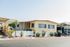 Charming yellow mobile home with manicured garden and private driveway, offering a cozy and inviting lifestyle.