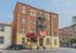 Charming historic brick apartment building with classic architecture and vibrant landscaping.