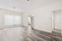 Bright and spacious living room with modern laminate flooring, large windows, and sleek vertical blinds, perfect for an inviting home atmosphere.