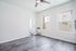 Bright and airy room featuring sleek hardwood floors, large windows, and a modern ceiling fan, ideal for a contemporary living space.