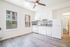 Bright and modern kitchen with white cabinetry, stylish backsplash, and large windows inviting abundant natural light.
