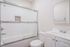 Modern bathroom with elegant glass shower, sleek tile accents, and stylish vanity in a bright, welcoming space.