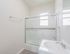 Bright, modern bathroom with a sleek glass shower, elegant vanity, and natural light from large windows.