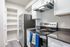 Modern kitchen boasting sleek stainless steel appliances, pristine white cabinets, and stylish open shelving for a contemporary touch.