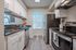 Modern kitchen with sleek stainless steel appliances, elegant white cabinetry, and stylish laminate flooring.
