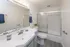 Bright and modern bathroom with sleek fixtures, large mirror, and stylish shower enclosure.