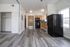 Bright and inviting apartment featuring a modern kitchen with wooden cabinetry, sleek black appliances, and elegant laminate flooring.