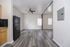 Modern apartment with chic laminate flooring, a sleek black refrigerator, and ample natural light.