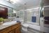 Modern bathroom with elegant marble tiles, sleek granite countertop, and stylish glass shower enclosure.