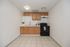 Charming kitchen with modern appliances, wood cabinetry, and sleek tile flooring, perfect for culinary enthusiasts.