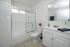 Bright and modern bathroom with sleek white fixtures, spacious countertop, and elegant tile flooring.