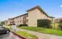 Charming two-story apartment building with well-maintained green lawns and ample parking space, perfect for a peaceful residential experience.