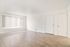 Bright and airy living space with sleek laminate flooring, large window with blinds, and modern white walls, perfect for a fresh start.