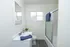 Chic and bright bathroom featuring modern fixtures, sleek vanity, and an inviting bathtub with frosted glass slider.