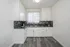 Bright, modern kitchen with elegant white cabinetry, sleek grey counters, and stylish geometric backsplash, ideal for culinary creativity.
