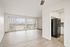 Bright and airy living space featuring large windows with vertical blinds, open floor plan, and inviting kitchen area.