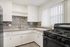 Modern kitchen with sleek cabinetry, stylish tile backsplash, and large window for ample natural light.