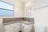 Bright bathroom with modern fixtures, elegant tiled backsplash, and abundant natural light.