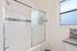 Bright and modern bathroom with elegant subway tiles and glass shower enclosure, featuring sleek countertop design.