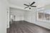 Bright and spacious living room with modern ceiling fan, large windows, and sleek hardwood floors.