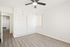 Bright and spacious bedroom with modern ceiling fan, elegant closet space, and sleek hardwood floors.