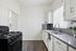 Bright, modern kitchen featuring sleek countertops, elegant cabinetry, and a stylish backsplash, perfect for culinary enthusiasts.