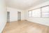 Bright inviting room with elegant hardwood floors, natural light pouring through large windows, and sleek white walls perfect for custom décor.