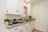 Charming kitchen with sleek countertops, stylish cabinets, and elegant window blinds creating a cozy ambiance.